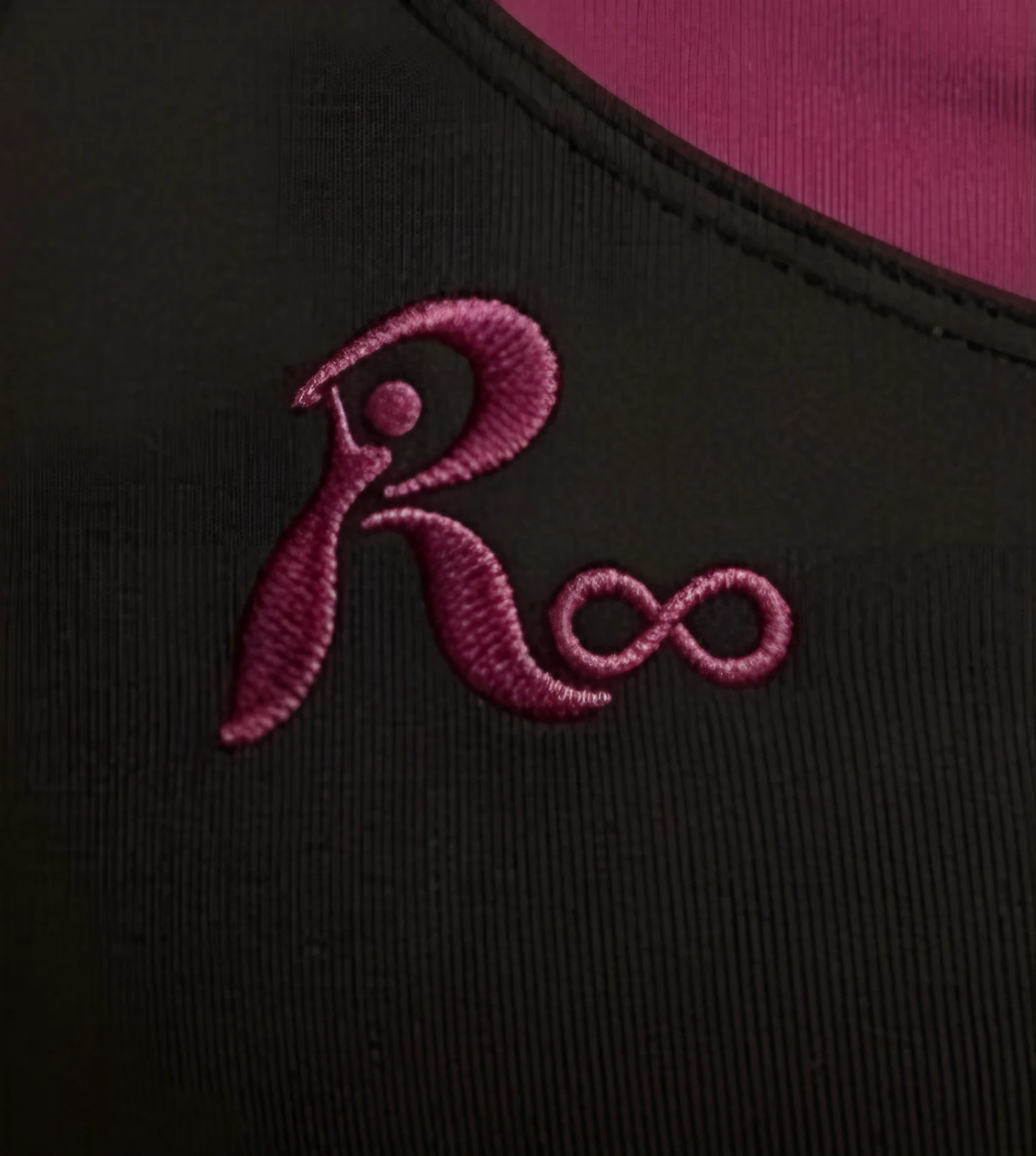 Logo R∞ bordado en ciruela sobre la musculosa negra